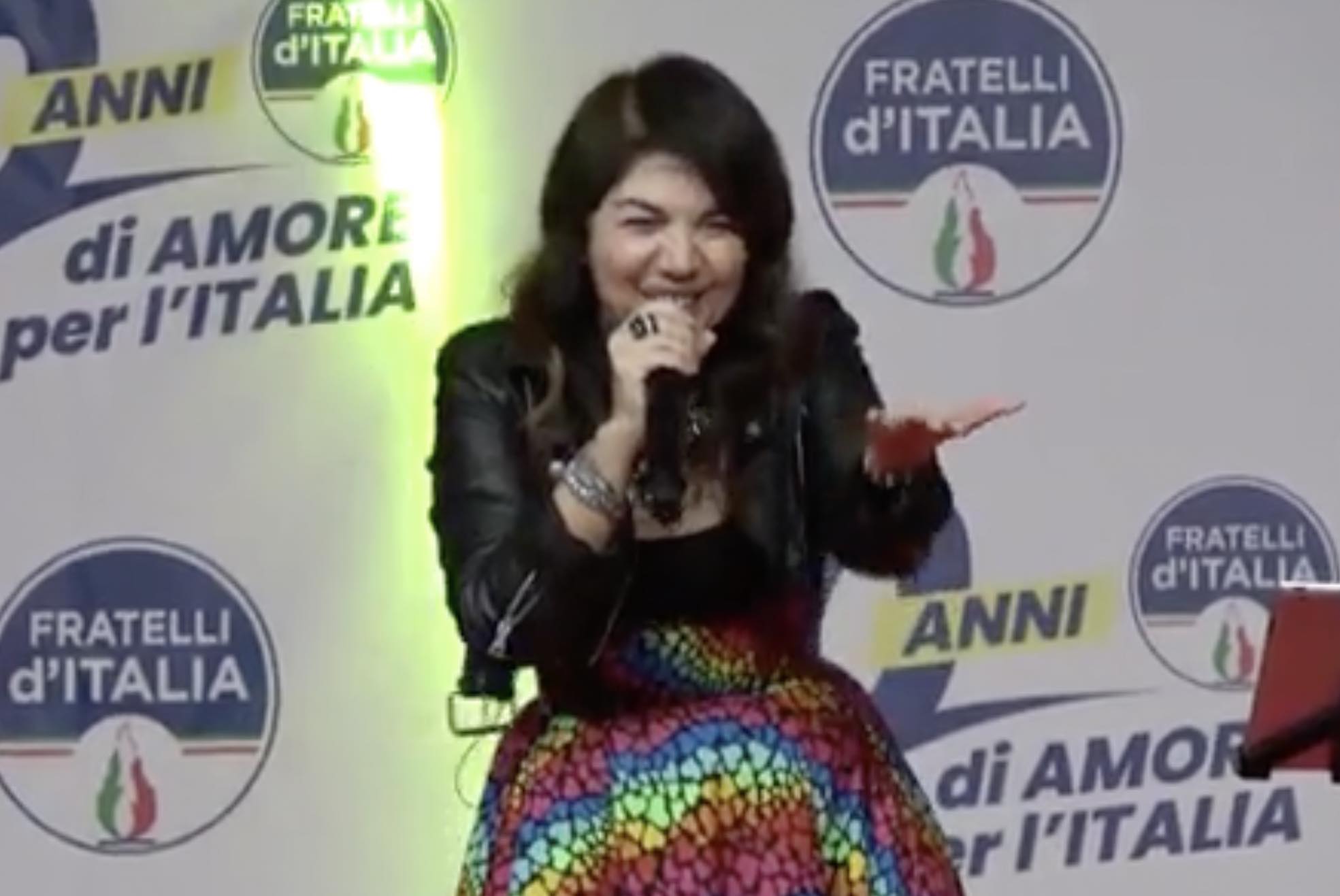 Cristina D’Avena alla festa FdI con gonna arcobaleno canta Lady Oscar: “Inno all’amore universale”